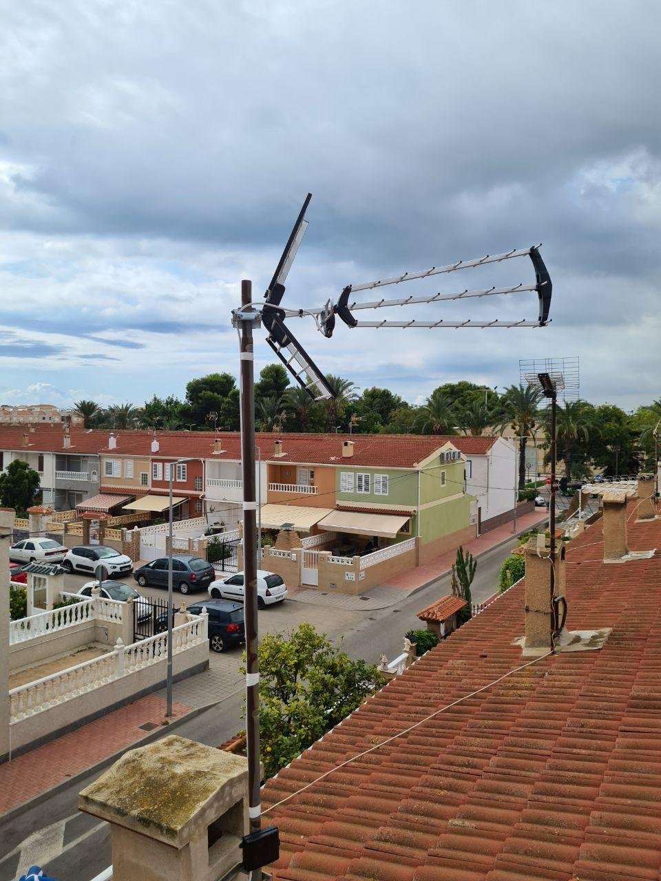 Antena TDT en mástil con vista a calle residencial en Torrevieja