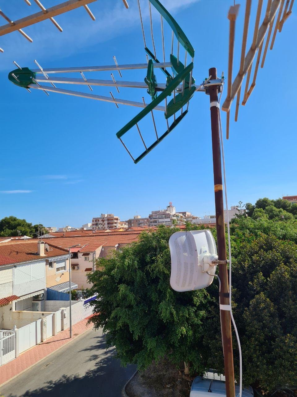 Antena TDT verde y caja de distribución en mástil
