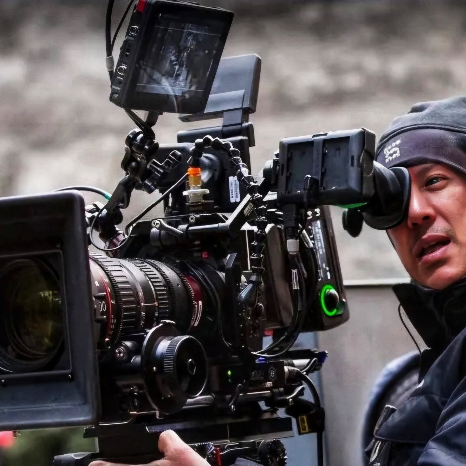 Camera operator looking through a cinema camera viewfinder on set