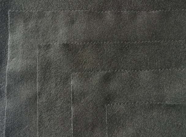 Flat layered needle-punched hair felt chest wadding panels stacked on a workbench