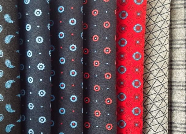 Rolled strips of needle-punched wool sleeve head felt coiled on a wooden table