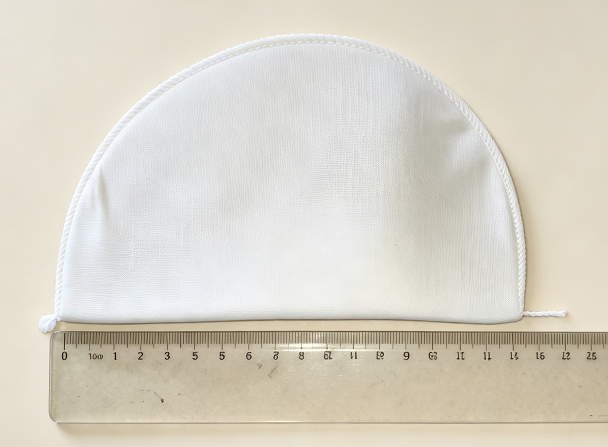 Covered shoulder pad with cotton cover fabric over needled felt core — Front view