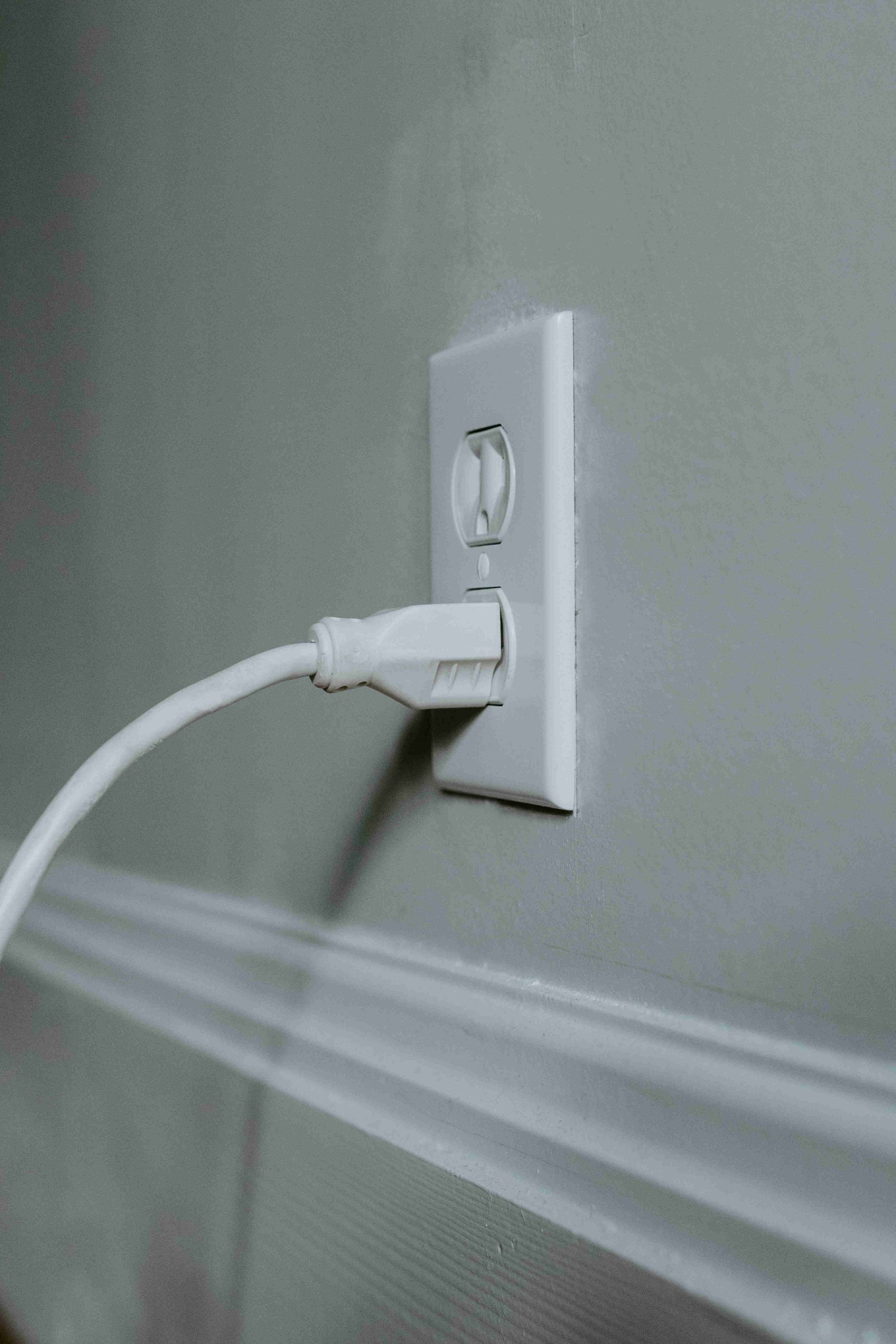 A white power outlet with a white cord plugged in, symbolizing direct connection.