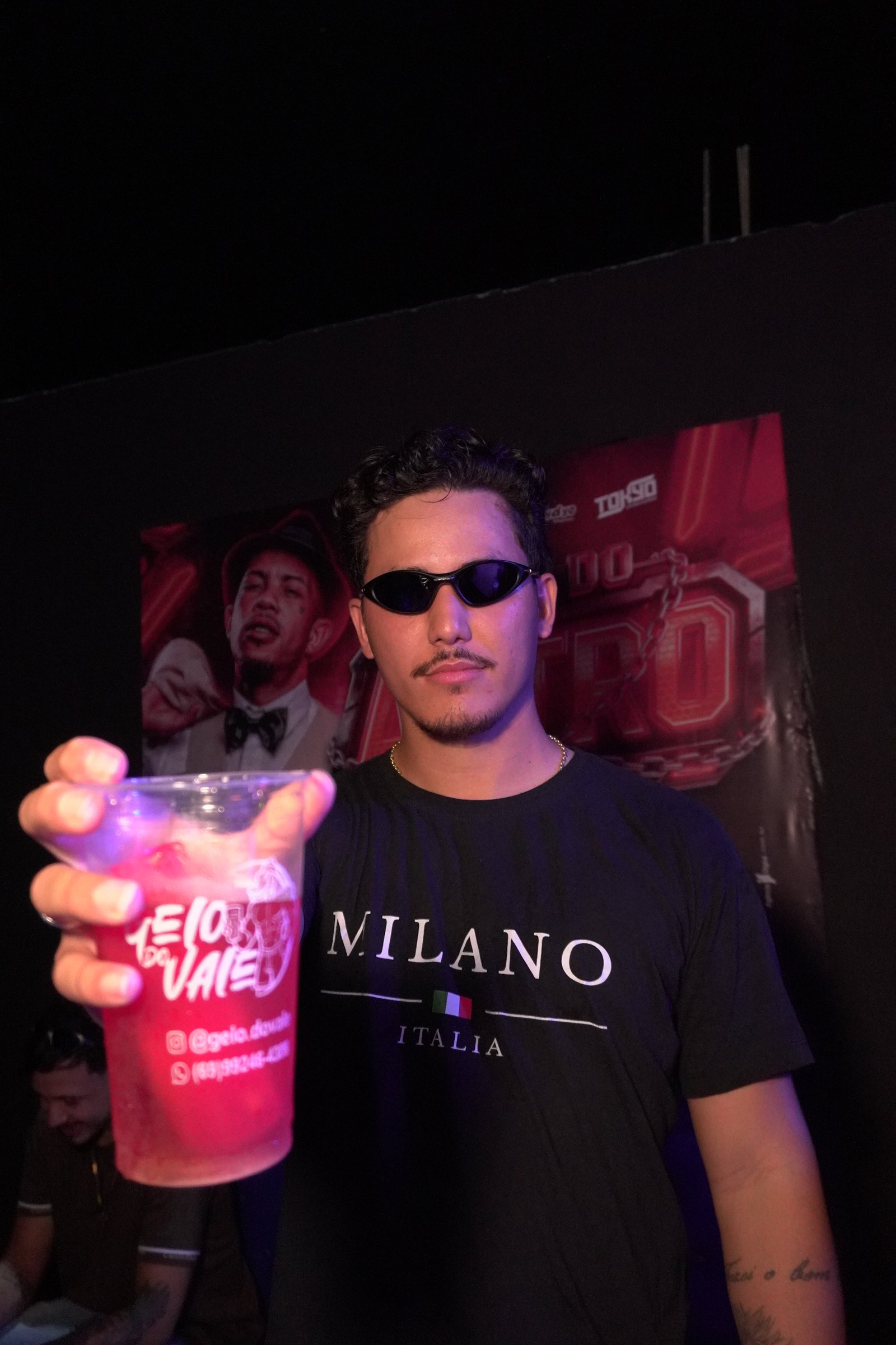 Homem em evento segurando drink Gelo do Vale com gelo colorido