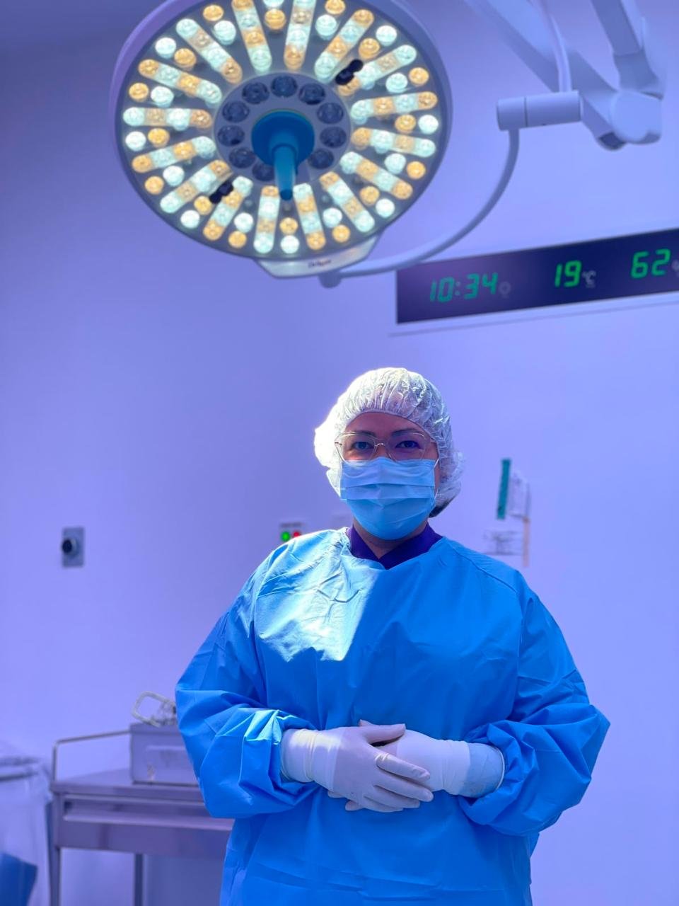 Dra. Tamara C. Muñoz Martínez en quirófano, con bata quirúrgica y lámpara de cirugía