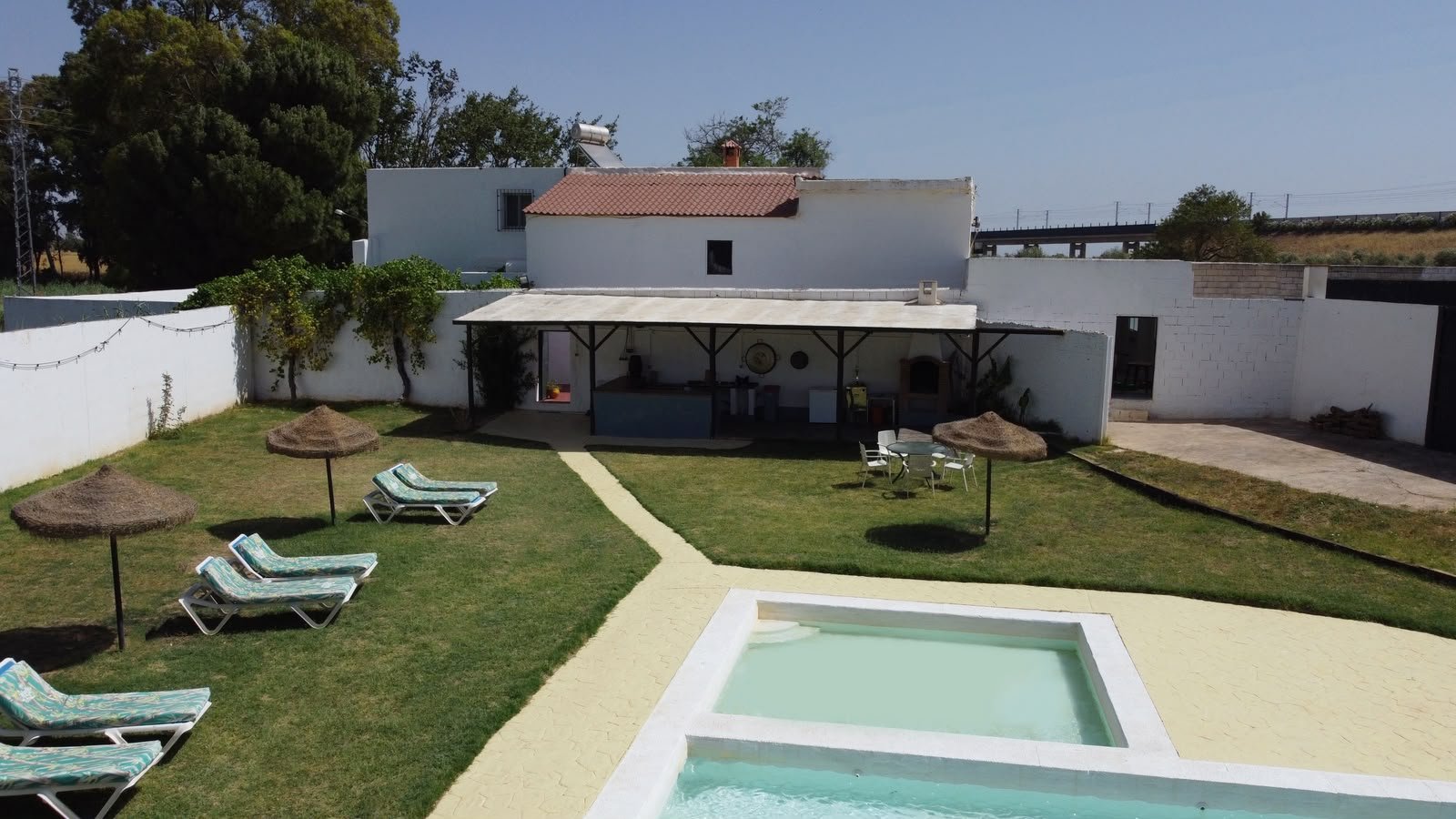 Large pool with lawn and parasols at Casa Rural La Vega