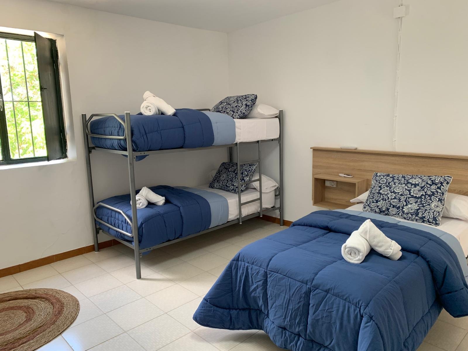 Room with a bunk bed and a double bed in the country house in Bobadilla