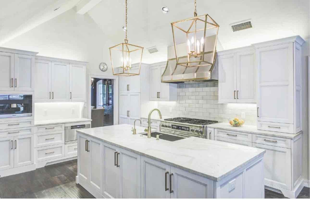 Modern minimalist white kitchen with herringbone backsplash, brass fixtures, and island seating in 40502 area