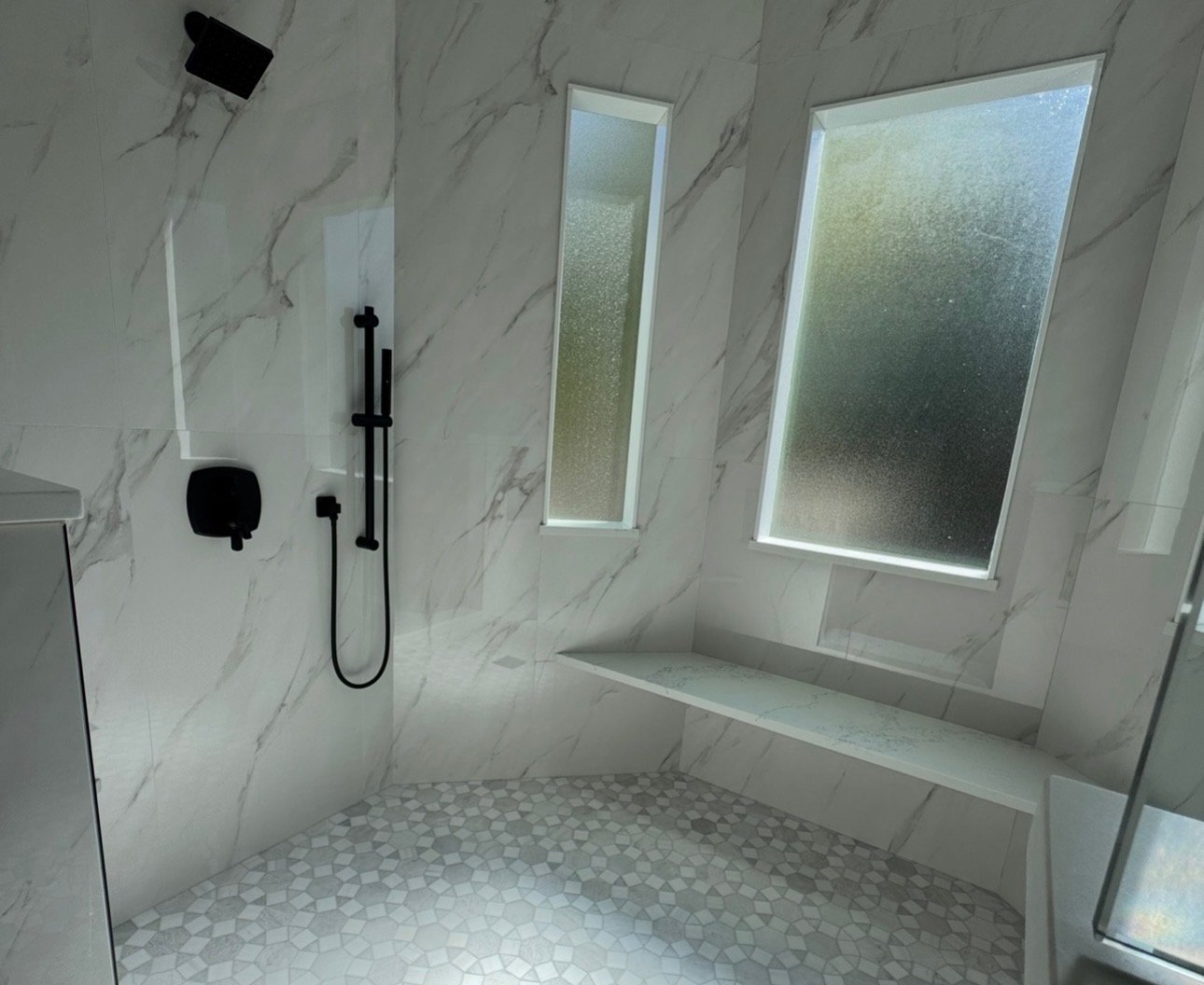 Modern spa bathroom with marble tiles and black fixtures in Lexington