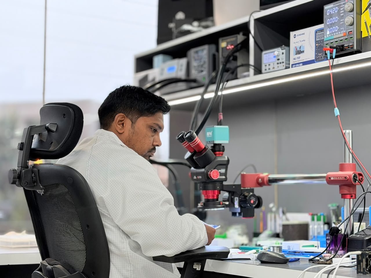 Mobile Fixit technician at a microscope station with test equipment on the bench