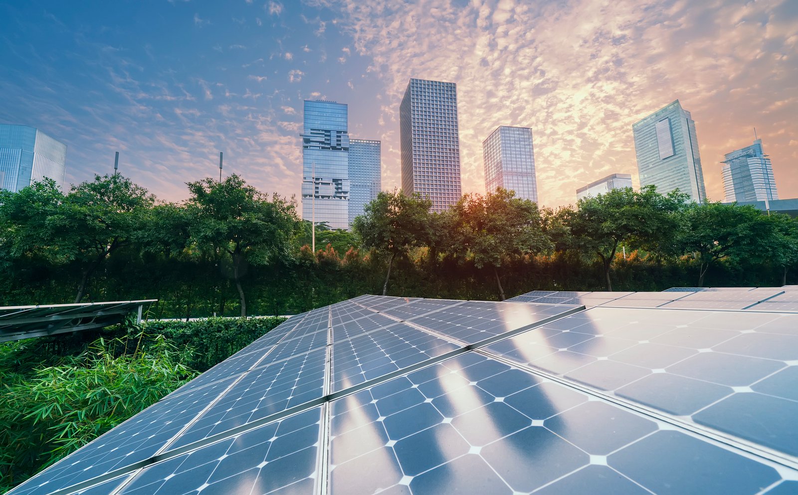 Urban solar panels with buildings and sunset sky