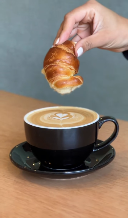 Golden croissant and latte on marble counter