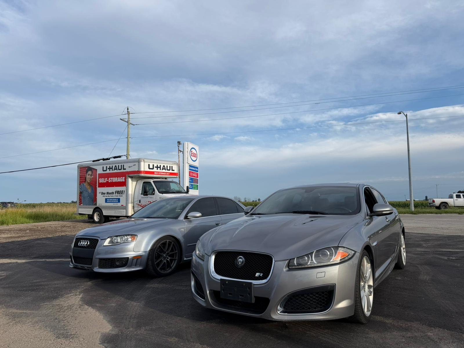 Silver Jaguar and Audi performance cars parked outside a fuel station