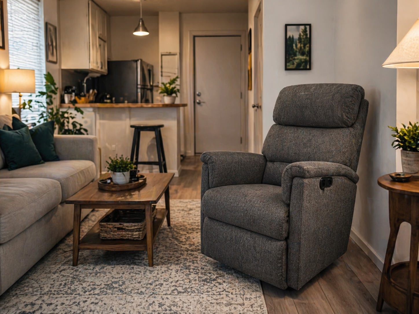 Gray compact power lift chair in a small apartment living room with sofa, coffee table, and kitchen visible