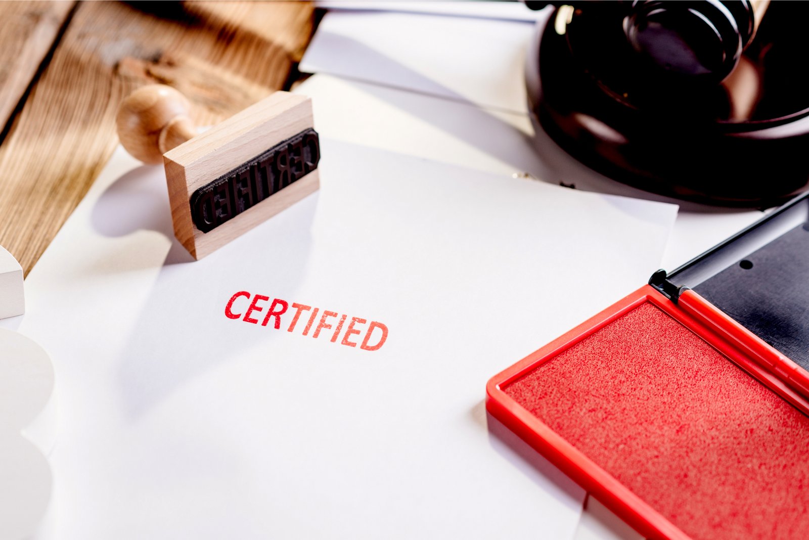 What Is a Certified Translation for UK Applications? Certified translation documents with a wooden stamp, red ink pad and judge’s gavel for UK legal applications