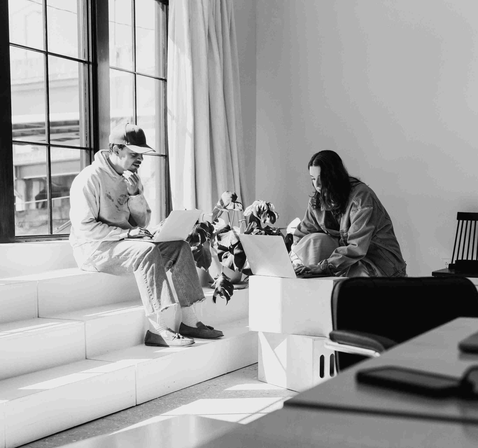 Diverse team collaborating around a table with laptops and notes