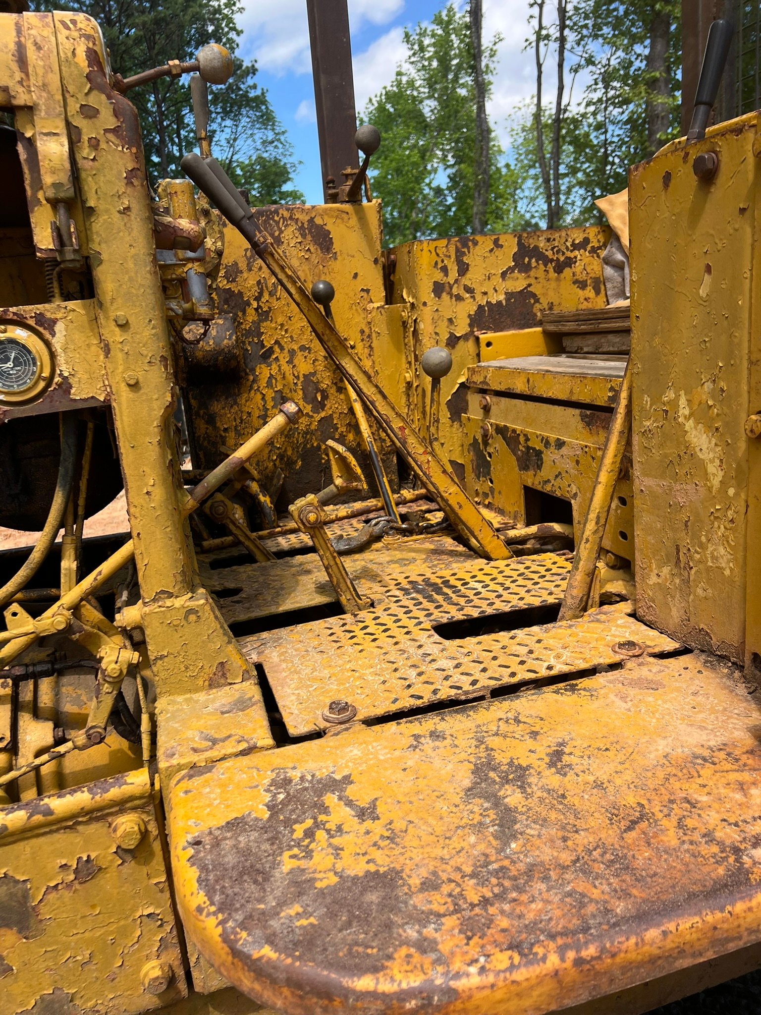 Close-up interior view of heavy equipment cab with yellow controls and levers