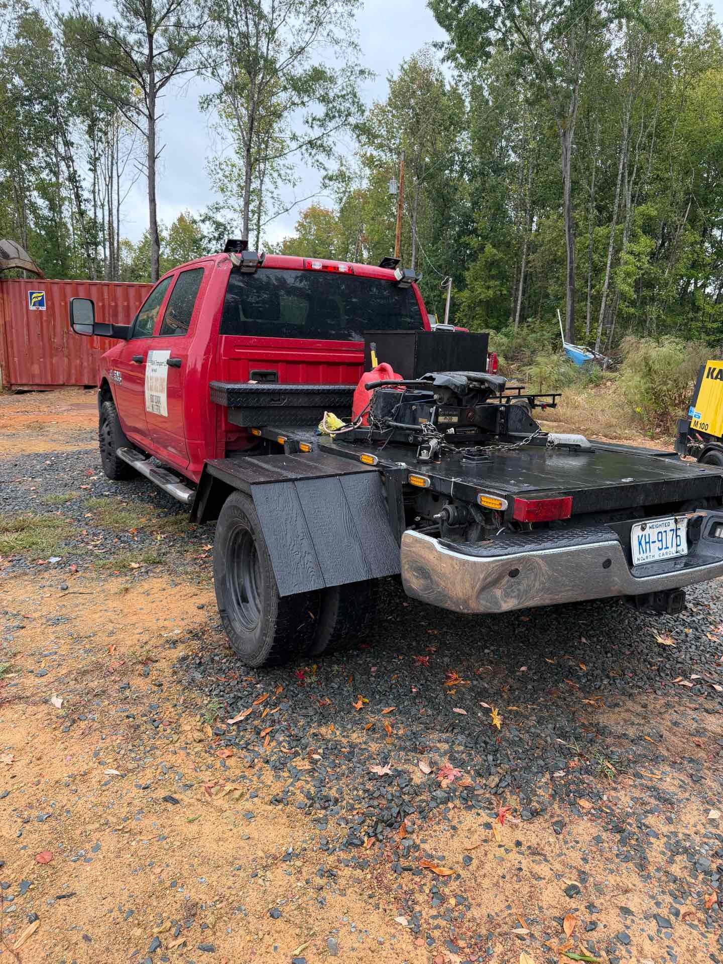 Rear view of the red Dodge Ram 3500 flatbed showing the repaired 6.7 Cummins turbo setup and gooseneck deck