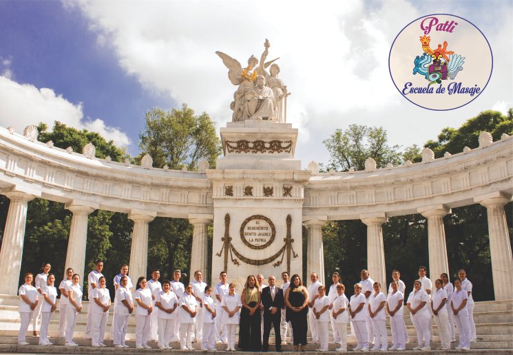 Estudiantes de la Escuela de Masaje Patli en uniforme blanco frente al Monumento a la Revolución