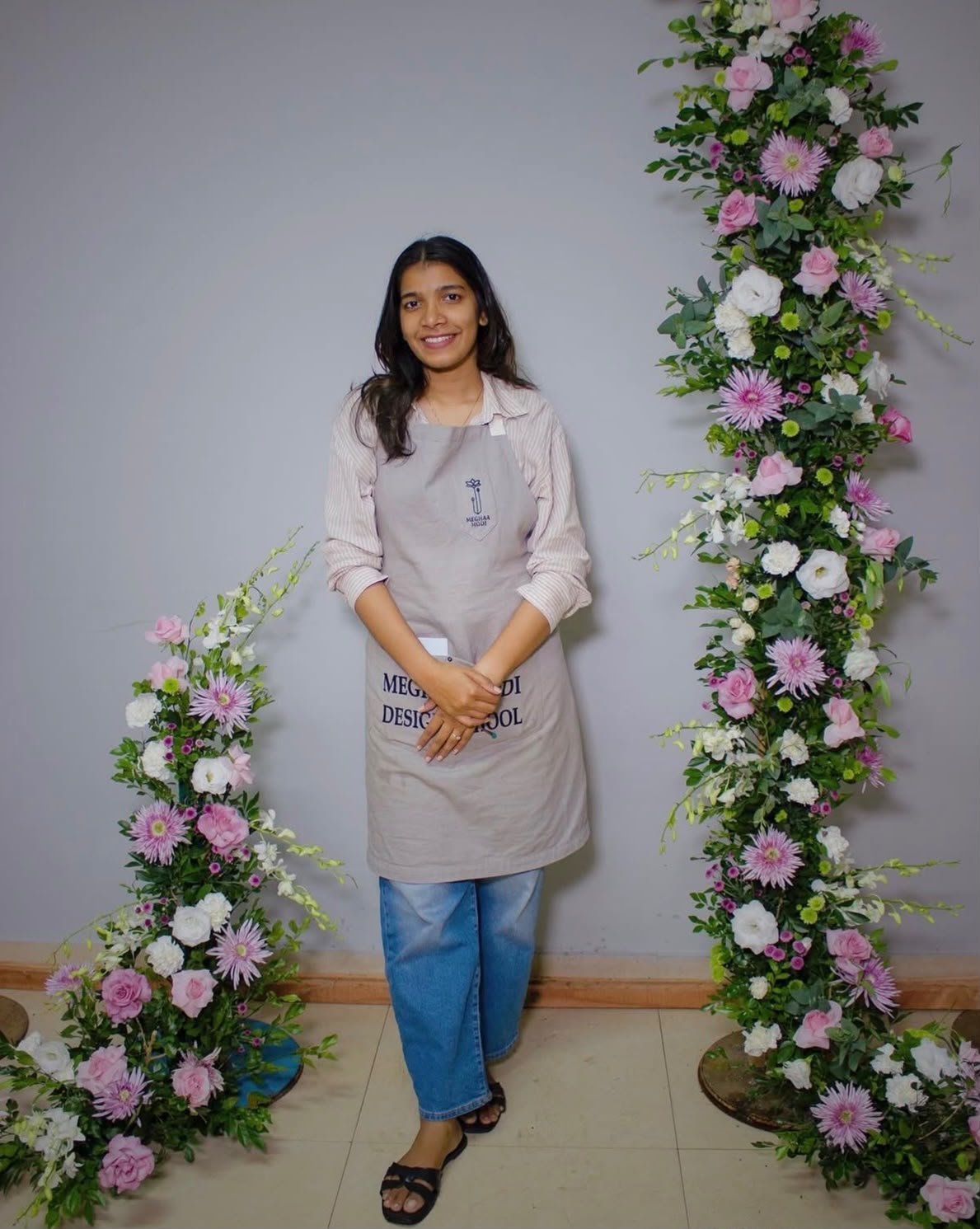 CHLORIS florist standing between two floral pillars in the Calicut studio
