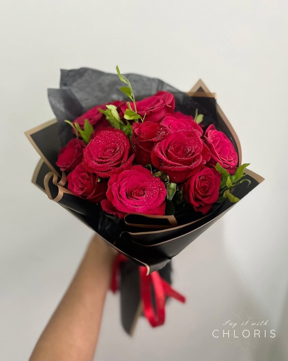 Fresh flowers and bouquet from CHLORIS — red roses wrapped in black paper with gold trim