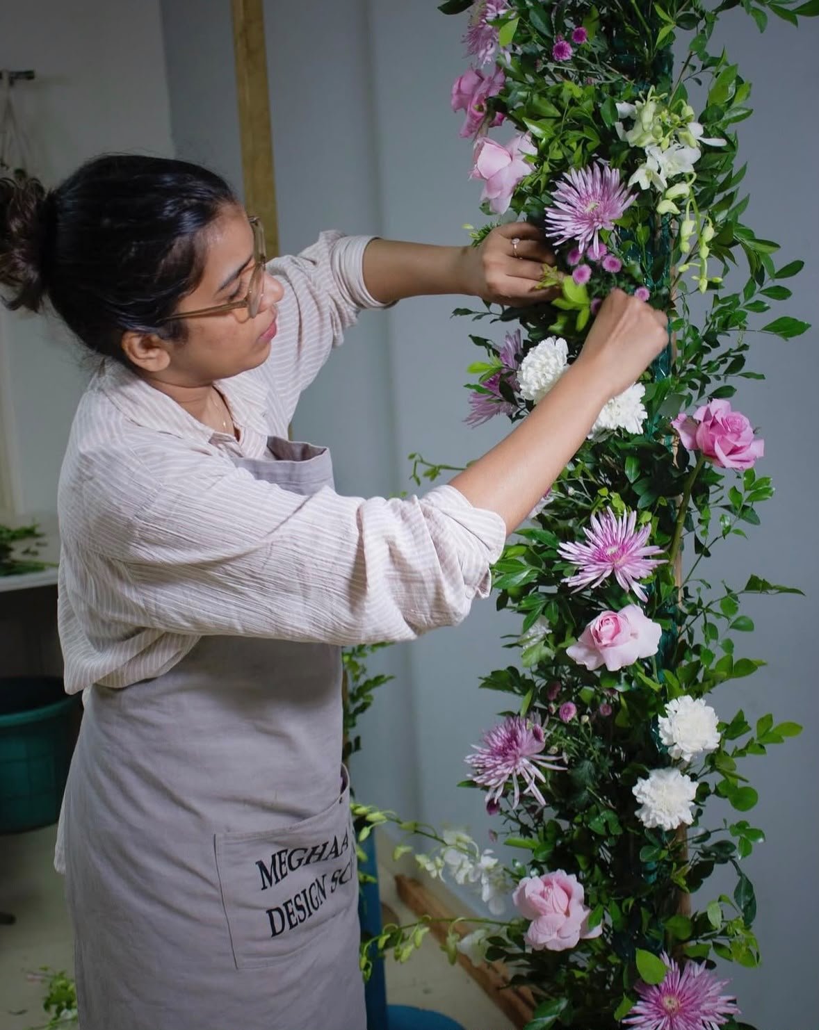 CHLORIS florist hand-arranging a floral pillar of roses and chrysanthemums