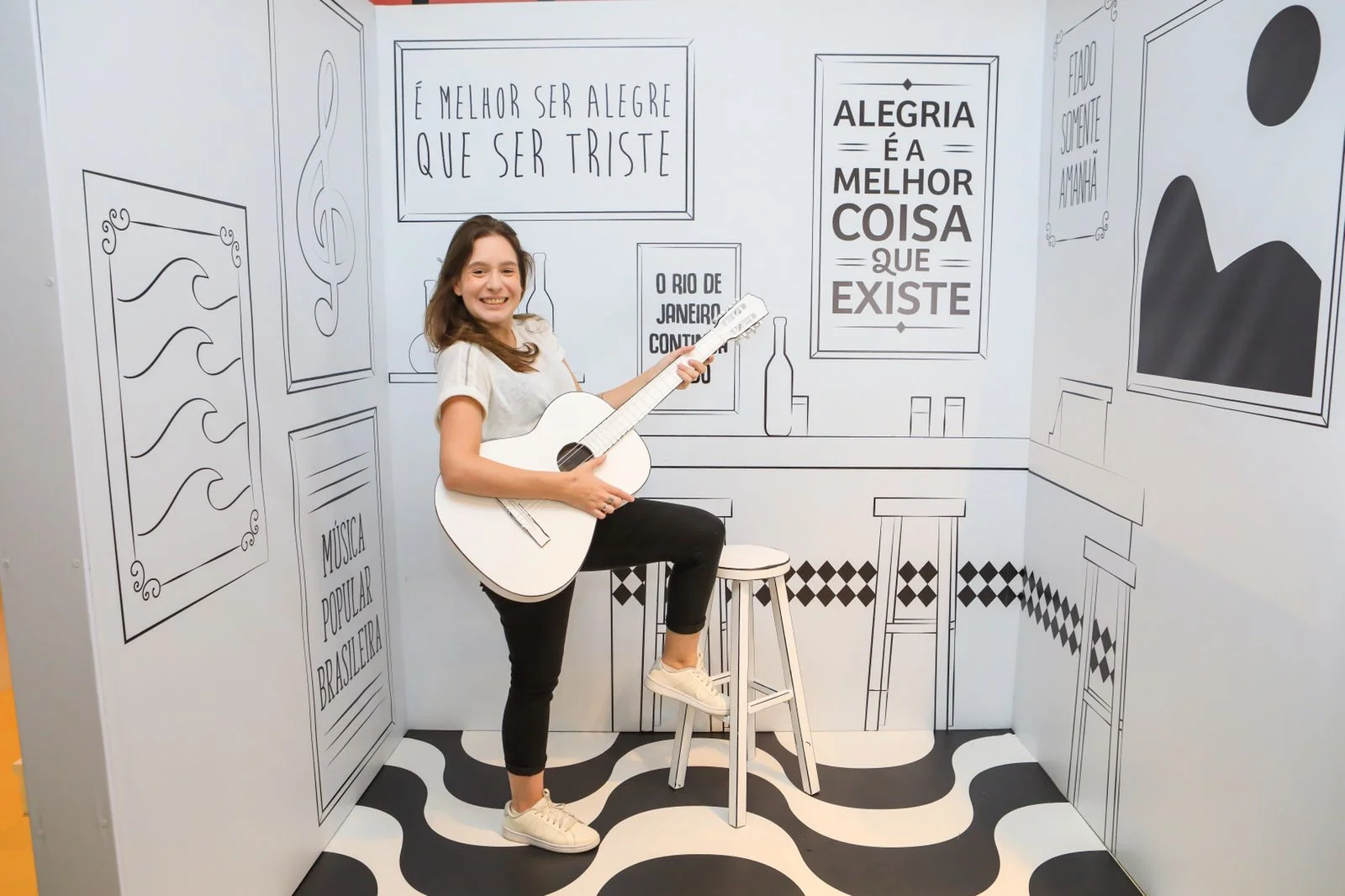 Visitante com violão branco no cenário desenhado da música popular brasileira
