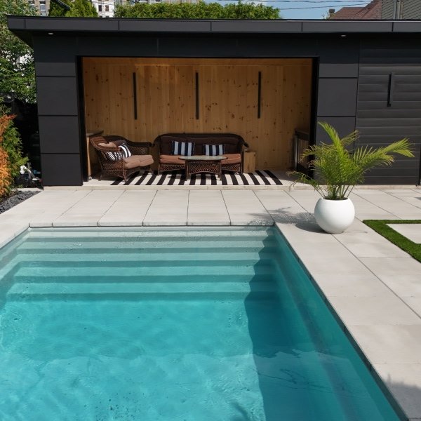 Piscine moderne avec garage noir et aménagement paysager contemporain