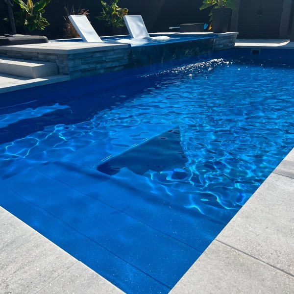 Finitions d'aménagement paysager autour d'une piscine creusée