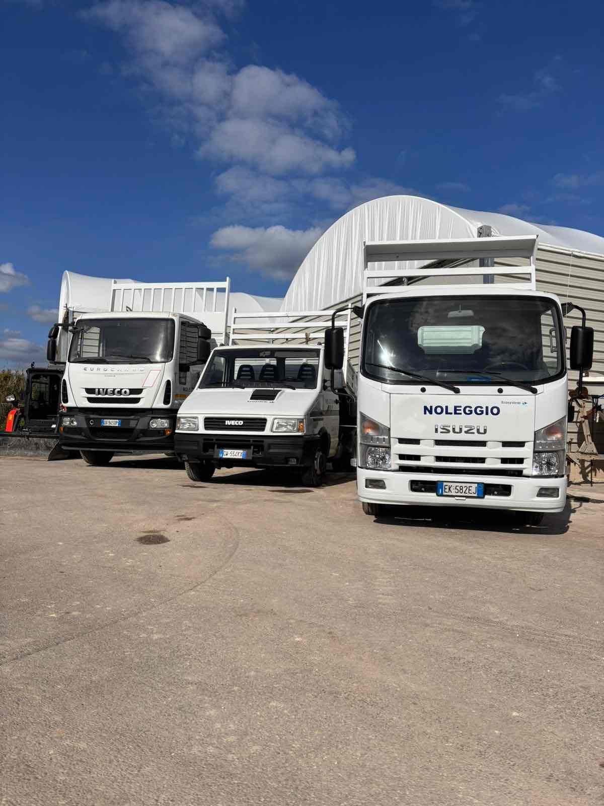 Thumbnail: Tre camion bianchi (Iveco, Isuzu, Isuzu) con cassoni