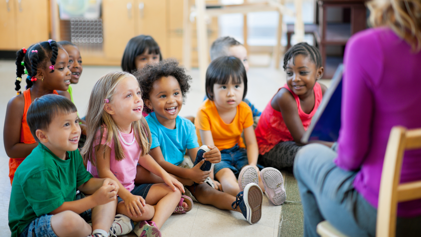 Children gathered around a teacher during a classroom activity
