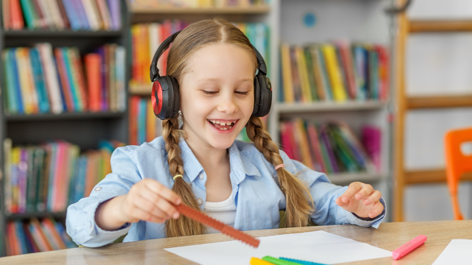 Child wearing headphones and listening at a desk