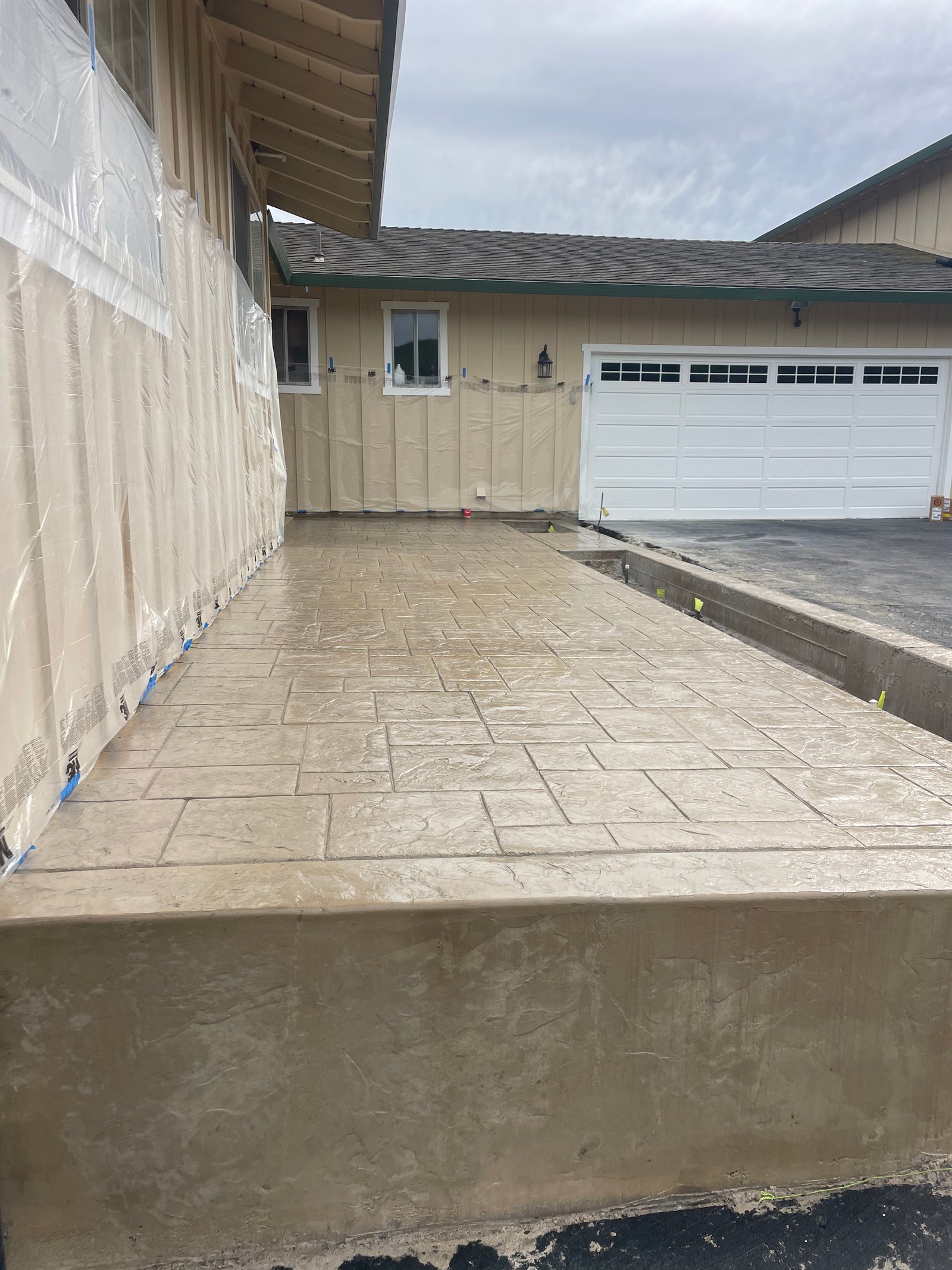 Concrete patio with decorative stamped pattern and white garage door in background