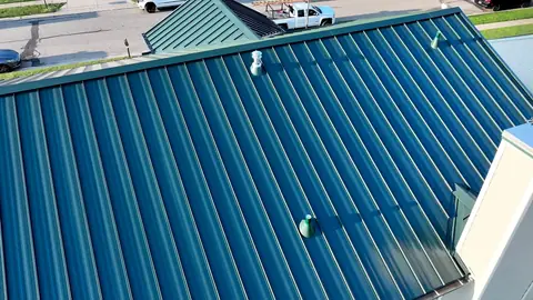 Standing-seam metal roof panels with pipe boots and vents