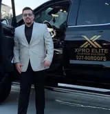 Ryan Sheehan, owner of XPRO ELITE Exterior Builders, standing beside his XPRO ELITE truck