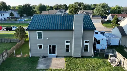 Rear elevation of a Xenia home with a new metal roof and new gray siding