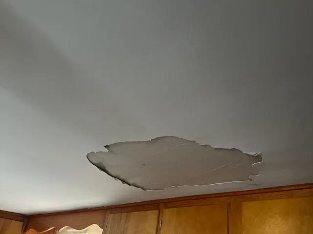 Ceiling drywall broken open by water from a roof leak in a Springfield, Ohio home