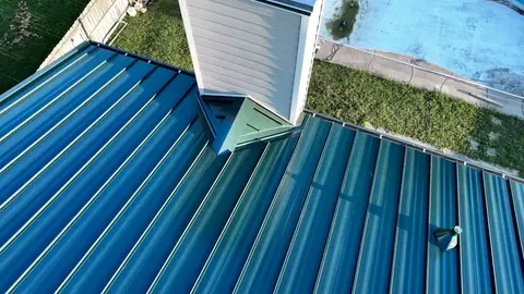 Close-up of chimney cricket flashing and standing seams on a new metal roof