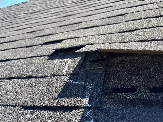 Creased and missing shingle tabs marked with chalk on a roof in Piqua, Ohio