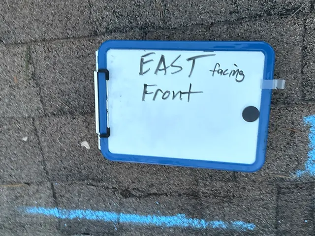 Whiteboard labeling the east-facing front slope beside chalk-marked damage during a Milford, Ohio inspection