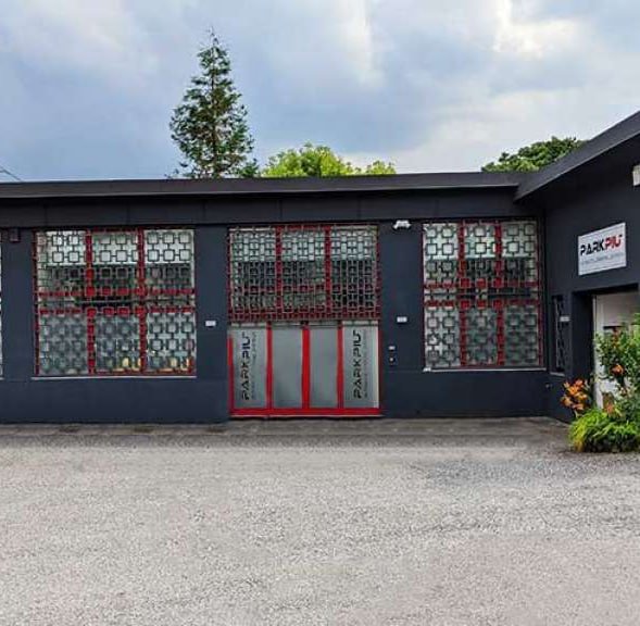 Estructura PARKPIÙ - edificio negro con puertas rojas y ventanas de rejilla