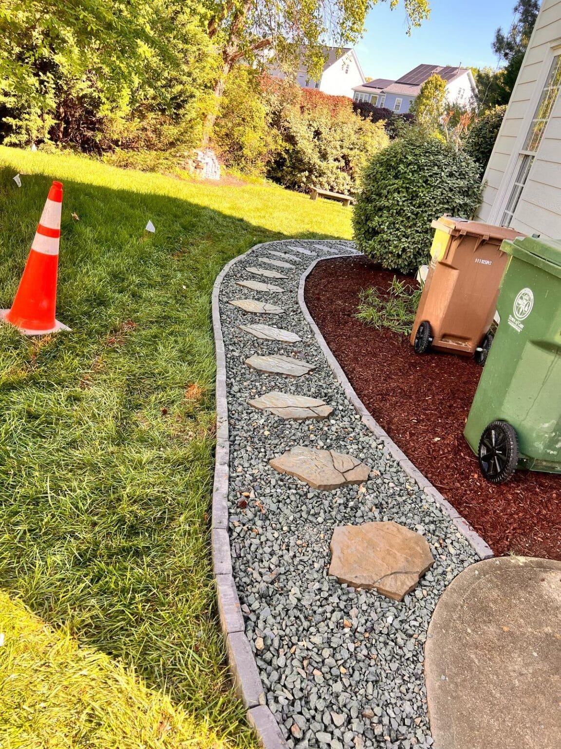 Curved stone walkway with patio and mulch beds
