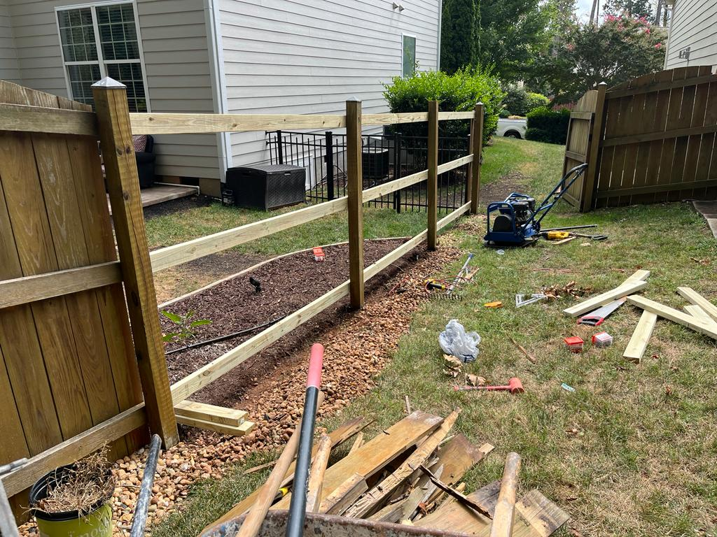 Fence post setting and rail installation in progress