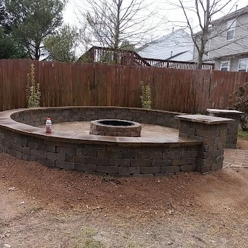 Circular patio with stone benches and fire pit area