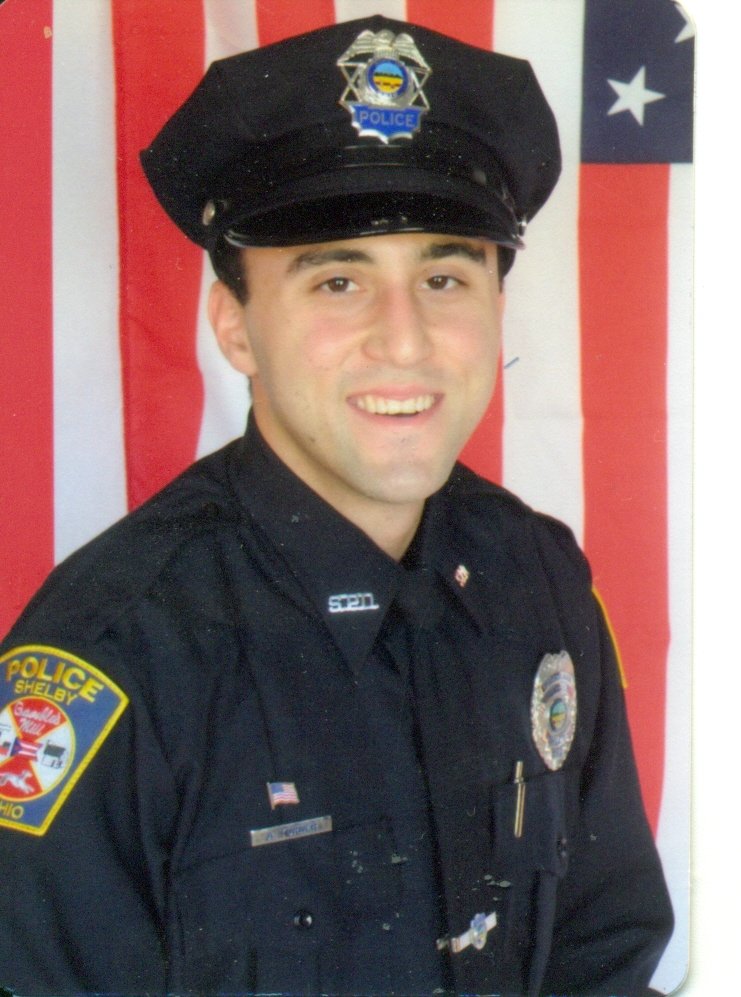 Adam Joseph Turner in Shelby Police uniform with American flag backdrop