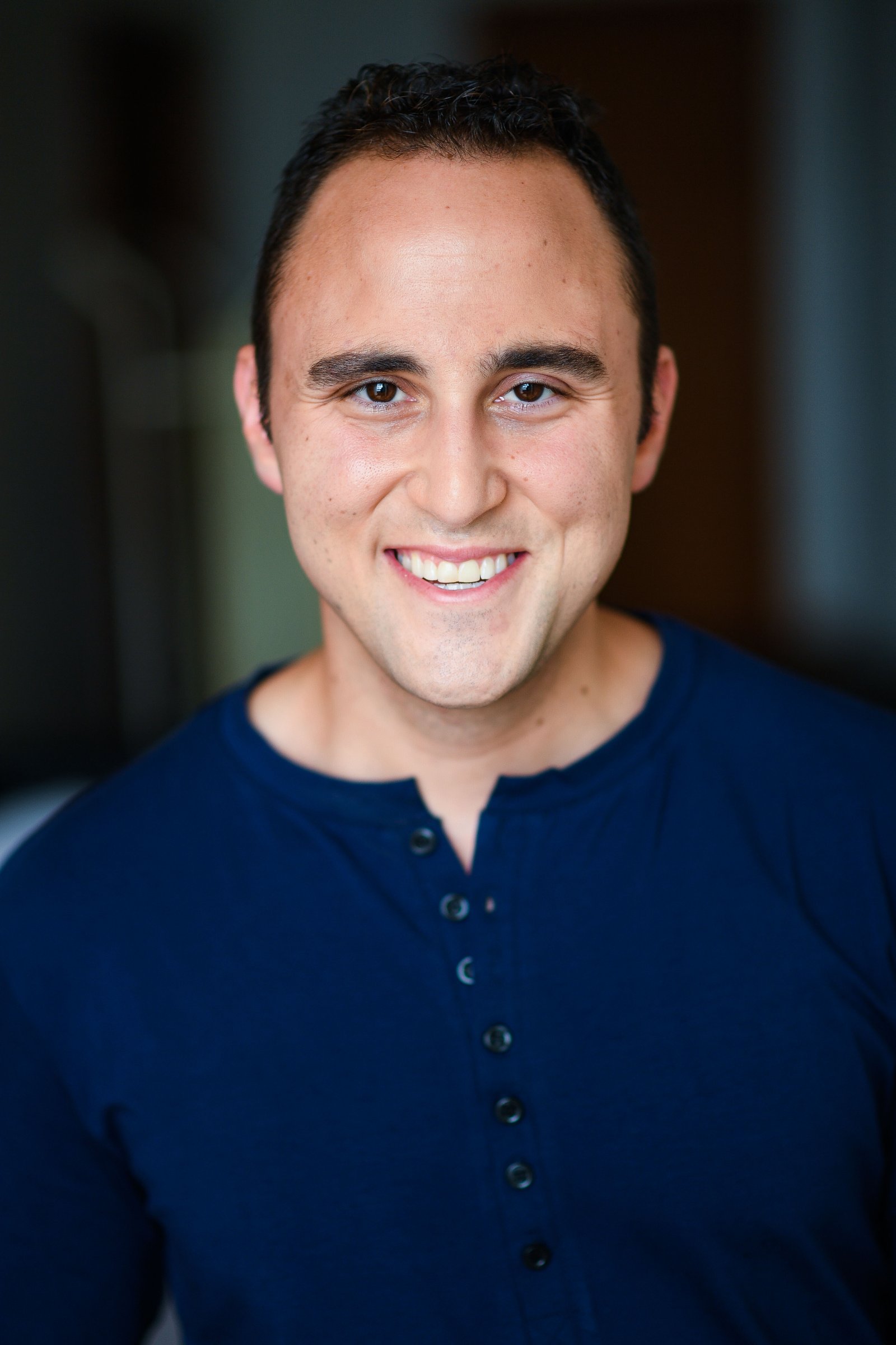 Adam Joseph Turner close-up headshot in a blue henley