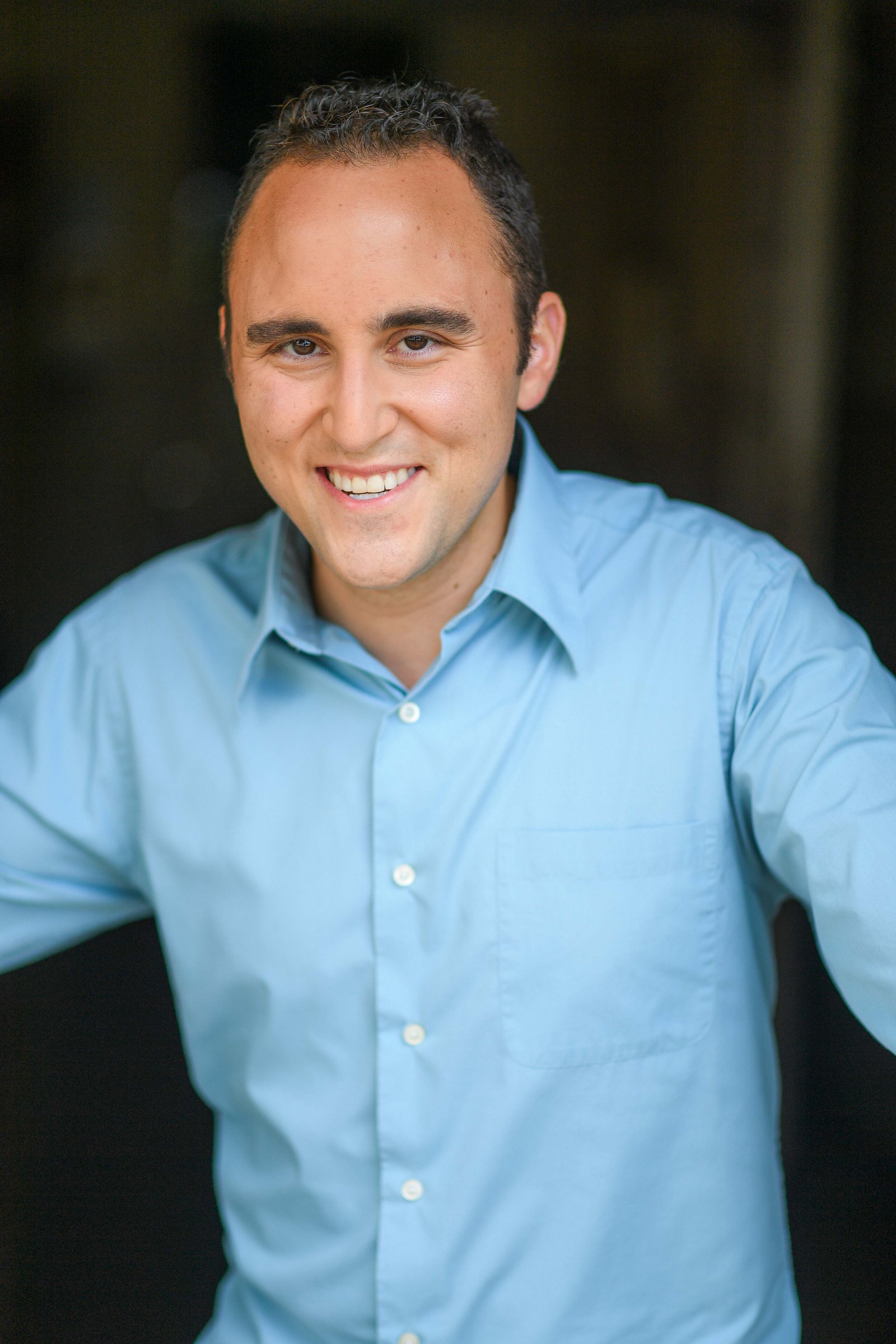 Adam Joseph Turner outdoor headshot in a light blue dress shirt