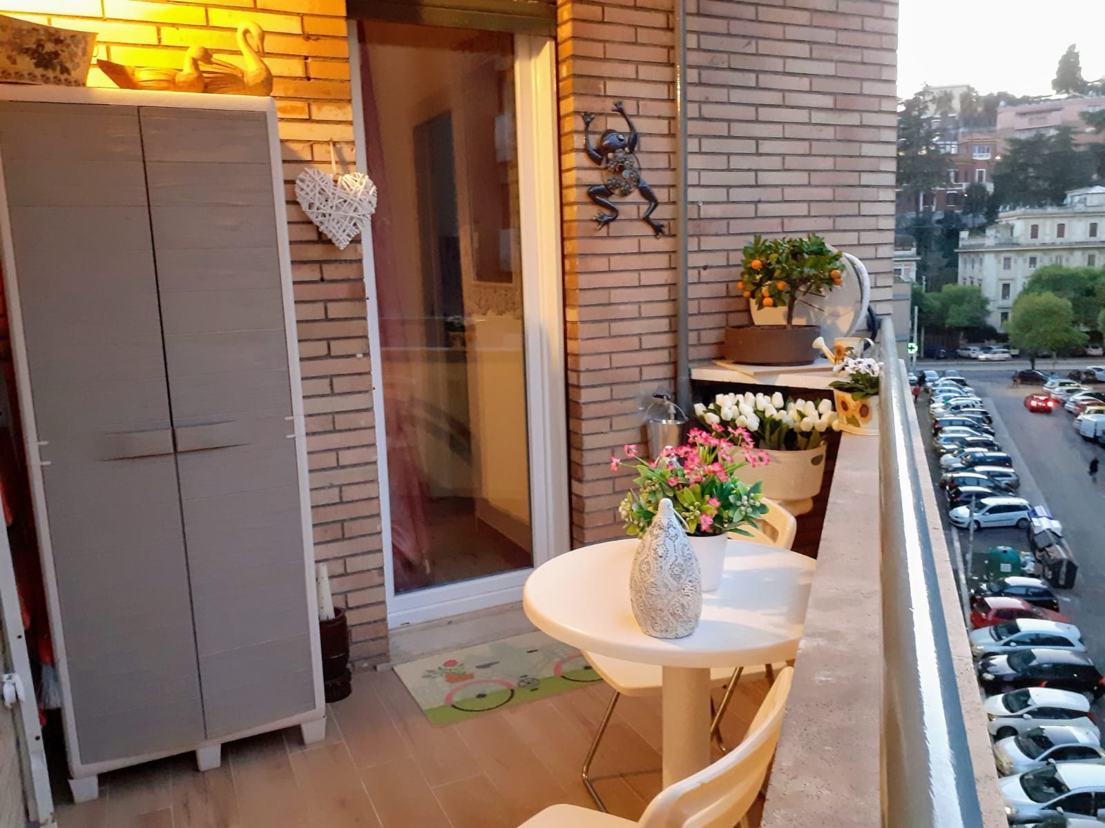 Balcony/terrace with flowers, table, chairs, Rome cityscape