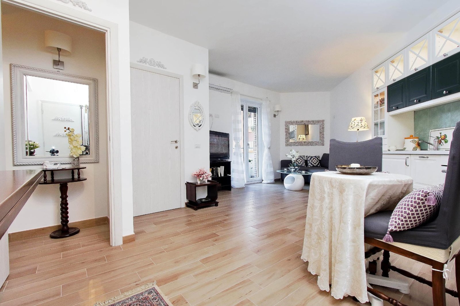 Living room with dark sofa, decorative mirror, wooden floor