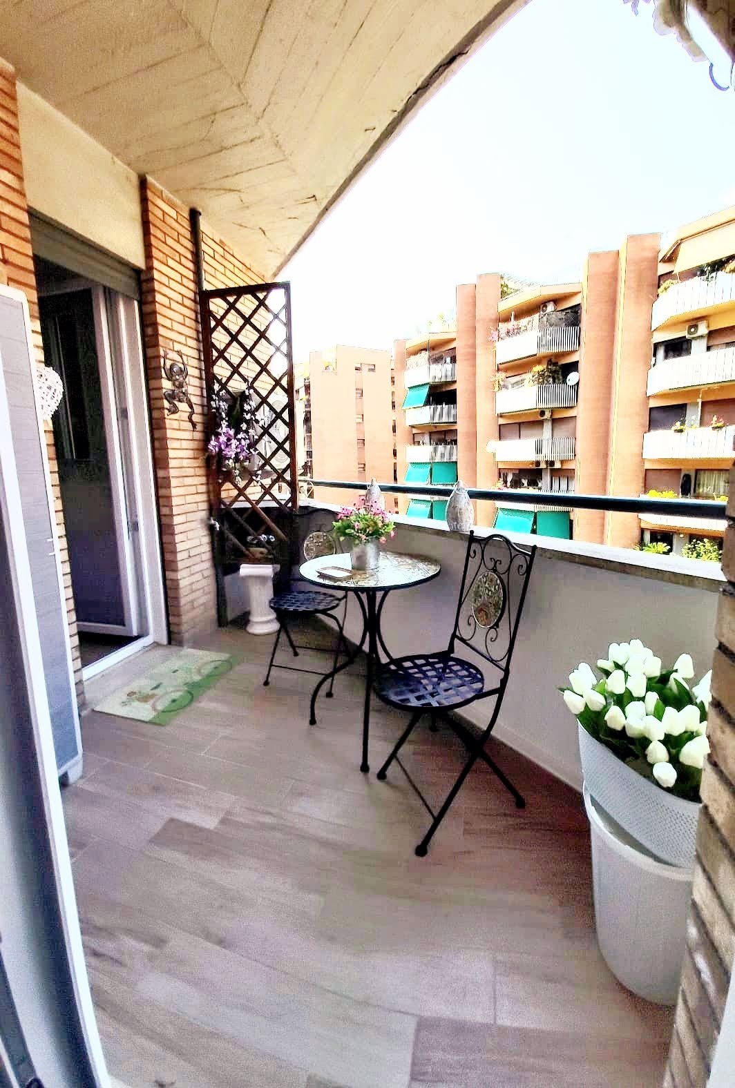 Balcony/terrace with table, chairs, flowers, and Rome view